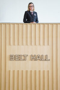 Mrs. Allison Belt stands near the sign bearing her name in the new Belt Hall